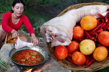 Cooking curry spicy red chili tomato with pork leg for lunch easy food in wild
