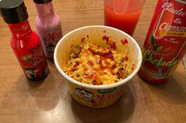 Samyang hot chicken cheese bowl with red jalapeños and manzana peppers, ground beef, American slice, and some extra hot sauce added. Picante chelada to wash it all down.