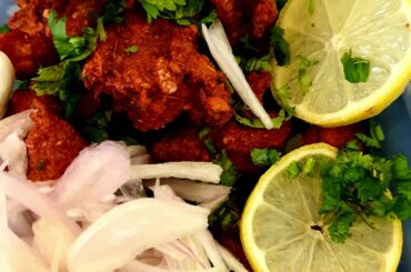 Spicy Indian Chicken Pakora Garnished with Lemon, Coriander & Onions
