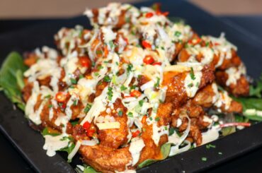 A mound of hot zingin' chicken (cayenne & reaper southern style coating), with cheese, chives, sour cream, and even more chillies!