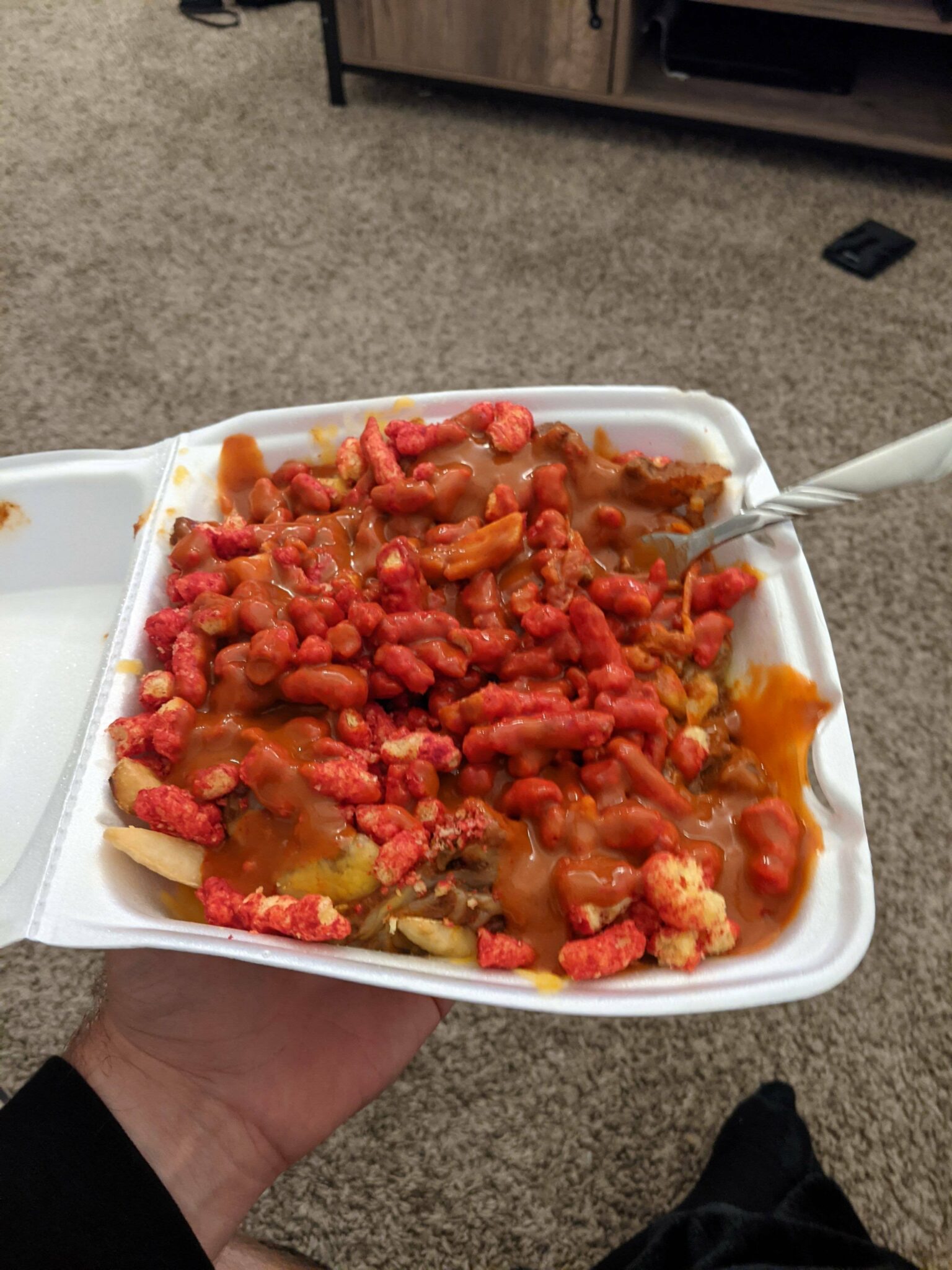 Chili cheese fries with extra hot cheetos topped with black label Valentina's hot sauce. Chili