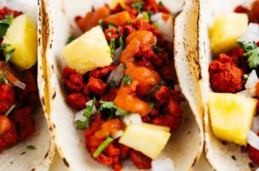 Tacos al pastor (plant-based) made with dried guajillo & chipotle chilies, topped with a spicy chipotle salsa