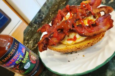 Bacon and a fried egg on toast with some ketchup and hotsauce