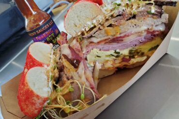 Hot cheeto bagel sandwich with brisket, bacon, ham, egg and hotsauce