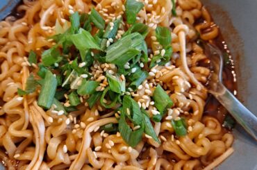 Buldak 2x Spicy with enoki mushrooms, scallions, and toasted sesame seeds