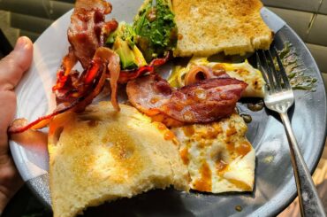 Just a big mess of bacon, over easy eggs, sourdough toast, and avocado, lovingly embraced by El Yucateco Caribbean hot sauce.