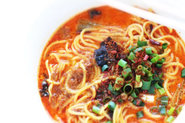 steamed fish heads covered in a blanket of diced chile peppers, scallions, and garlic - flower peppers