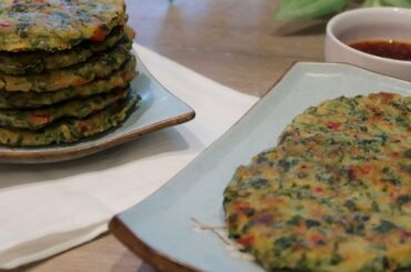 Korean pancake with perilla leaves, minari, chives, chili peppers, and shrimp