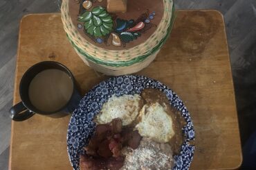 Eggs and refried beans, bacon and salsa roja.
