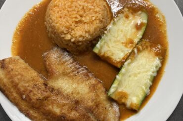 Calabasita rellenas de queso en salsa con arroz y tilapia.