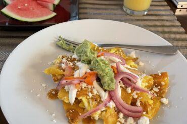 Let's continue simple. Eggs with tortilla, topped with pickled onion and habanero peppers as well as some queso fresco and guacamole. Some fruit to keep it balanced.