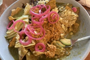 Chilaquiles con Cochinita Pibil, chili verde, cebolla morada encurtida, aquacate, queso cojita y salsa de habenero. La Libertad, Merida, Yucatan.