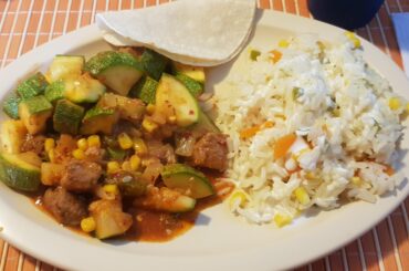 Calabacita con puerco en salsa de guajillo y arroz blanco con zanahoria, elote y crema