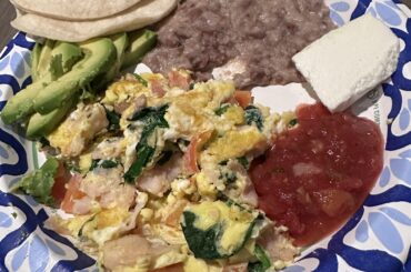 Breakfast how my mom made it, eggs with spinach, tomatoes and chopped ham; pinto beans, avocado, salsa, tortillas and queso fresco