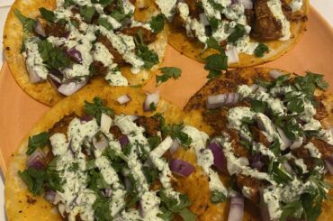 Homemade al pastor tacos with diced red onion, cilantro, and a cilantro lime crema.