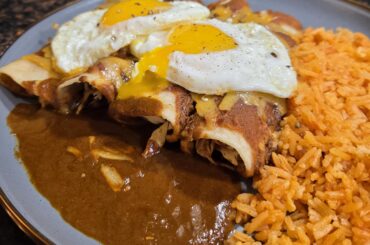 Chicken enchiladas with fried eggs.