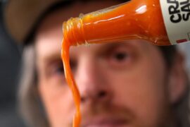 Founder Brian Ruhlmann pours a bottle of Mill City Red, one of Craic Sauce's hot sauces.