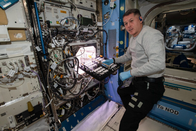 NASA astronaut Shane Kimbrough inserts a device called a science carrier into the Advanced Plant Habitat (APH), on July 12, 2021 as part of the Plant Habitat-04 experiment.
