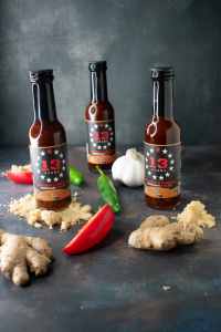 Three bottles of 13 Stars hot sauce.