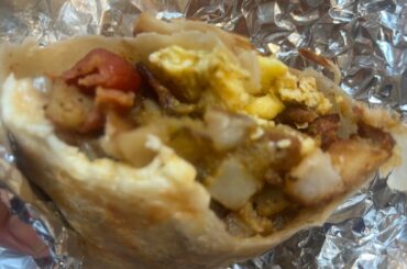 El mejor burrito de desayuno con huevos, chorizo con tocino, papas y salsa roja y queso fresco.