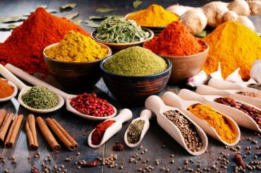 Variety of spices and herbs on kitchen table.