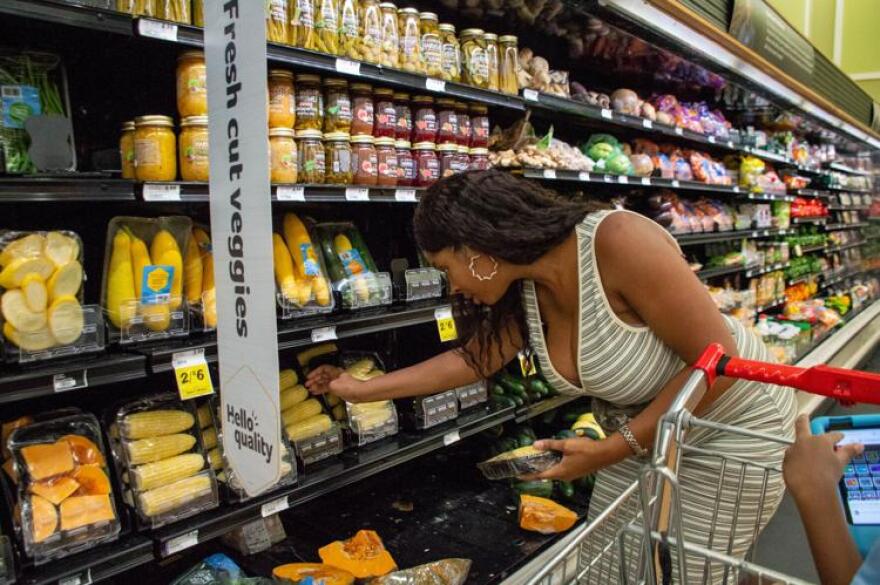 Natasha St. Cyr choosing BOGO produce to save money.