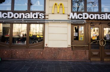 The exterior of a McDonald's restaurant with large signage and glass doors.