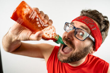 Mike Jack pouring hot sauce into his mouth