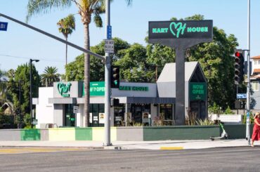 A restaurant building with a sign reading "Hart House" and palm trees nearby, located at an intersection.
