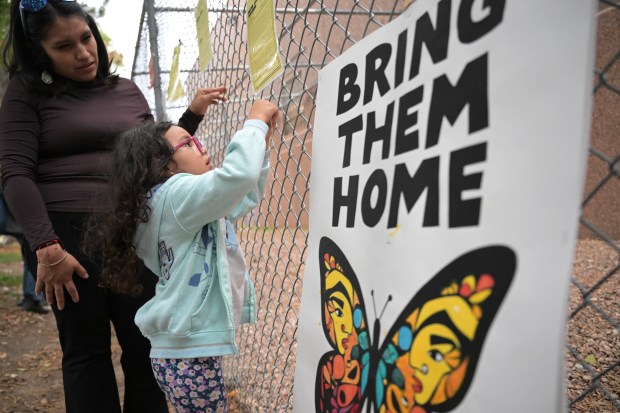 Andrea Loya, left, and her daughter Alitzel, 4, place copies of detainees' medical records on a fence outside the GEO Detention Facility in Aurora on Wednesday, Sept. 23, 2026. (Photo by Hyoung Chang/The Denver Post)