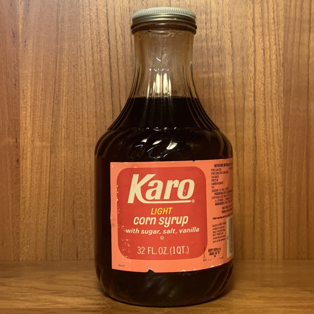 A glass bottle of Karo light corn syrup with a red label.